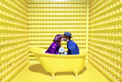 男女在黄色浴缸内接吻